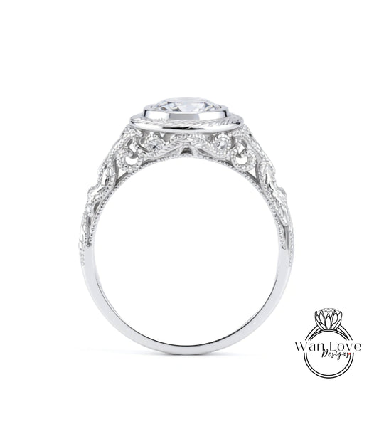 A close-up view of a silver ring with an intricate, decorative design around the band and a large central stone.