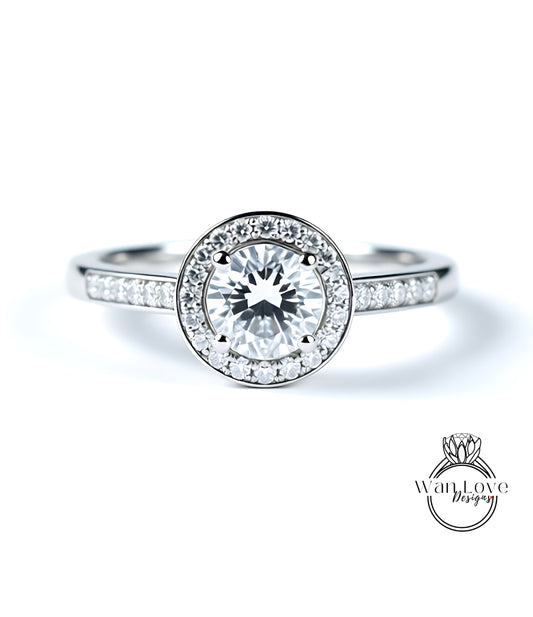 A close-up of a diamond engagement ring with a large central diamond surrounded by smaller diamonds, set in a silver band.