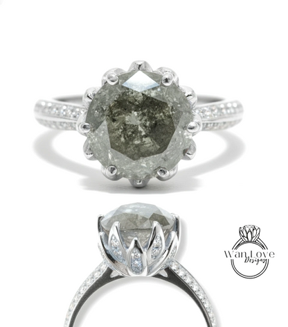 A silver ring with a large, irregularly shaped diamond as the centerpiece. The ring is set with smaller diamonds around the band, creating a sparkling effect.