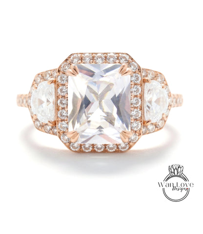A large, clear gemstone ring with a halo of smaller diamonds around the center stone.