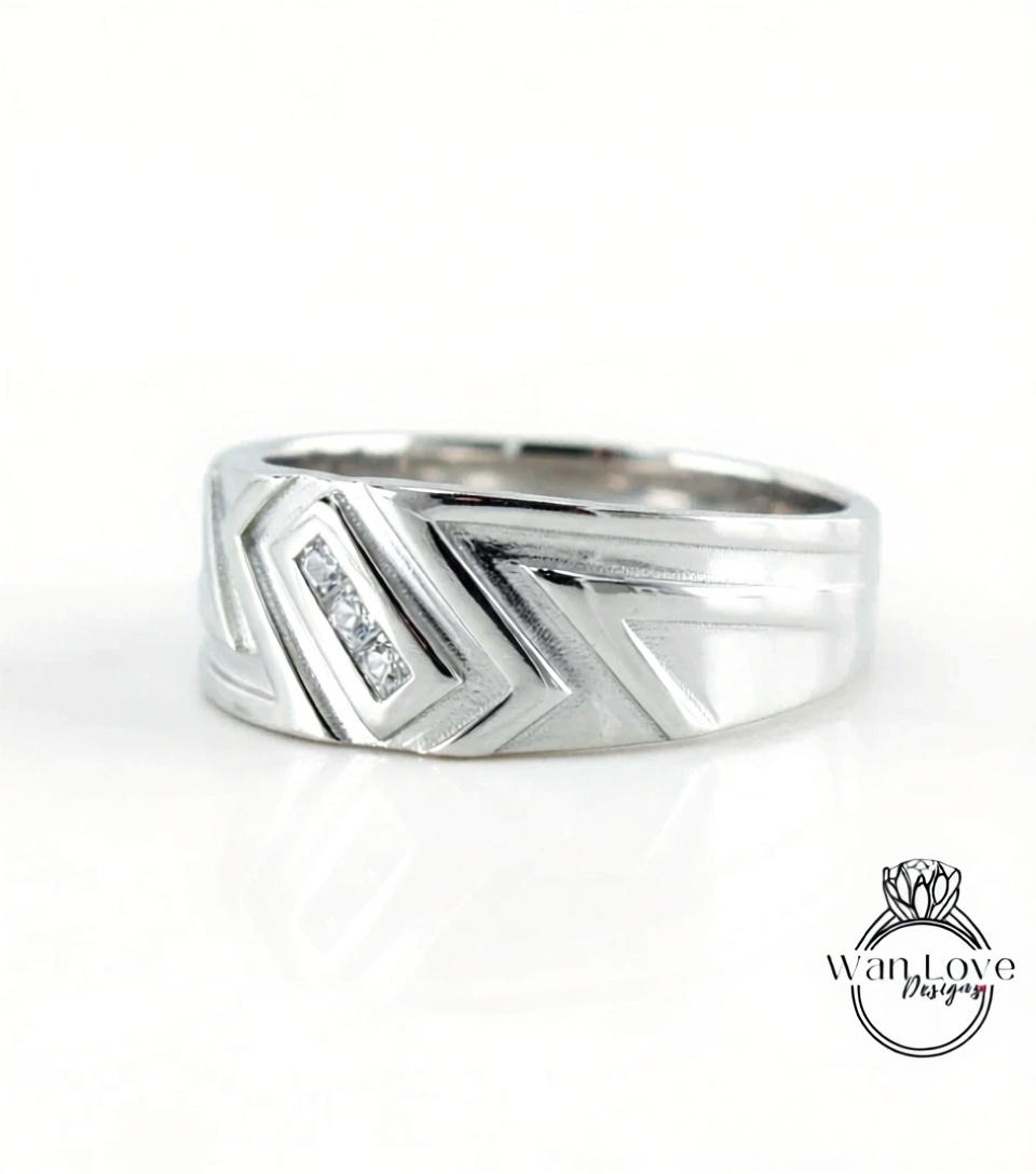 A silver ring with a geometric design and a small diamond accent.