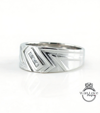 A silver ring with a geometric design and a small diamond accent.
