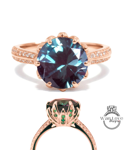 a large, blue gemstone ring with a gold band and a smaller ring with a green gemstone on the same finger.