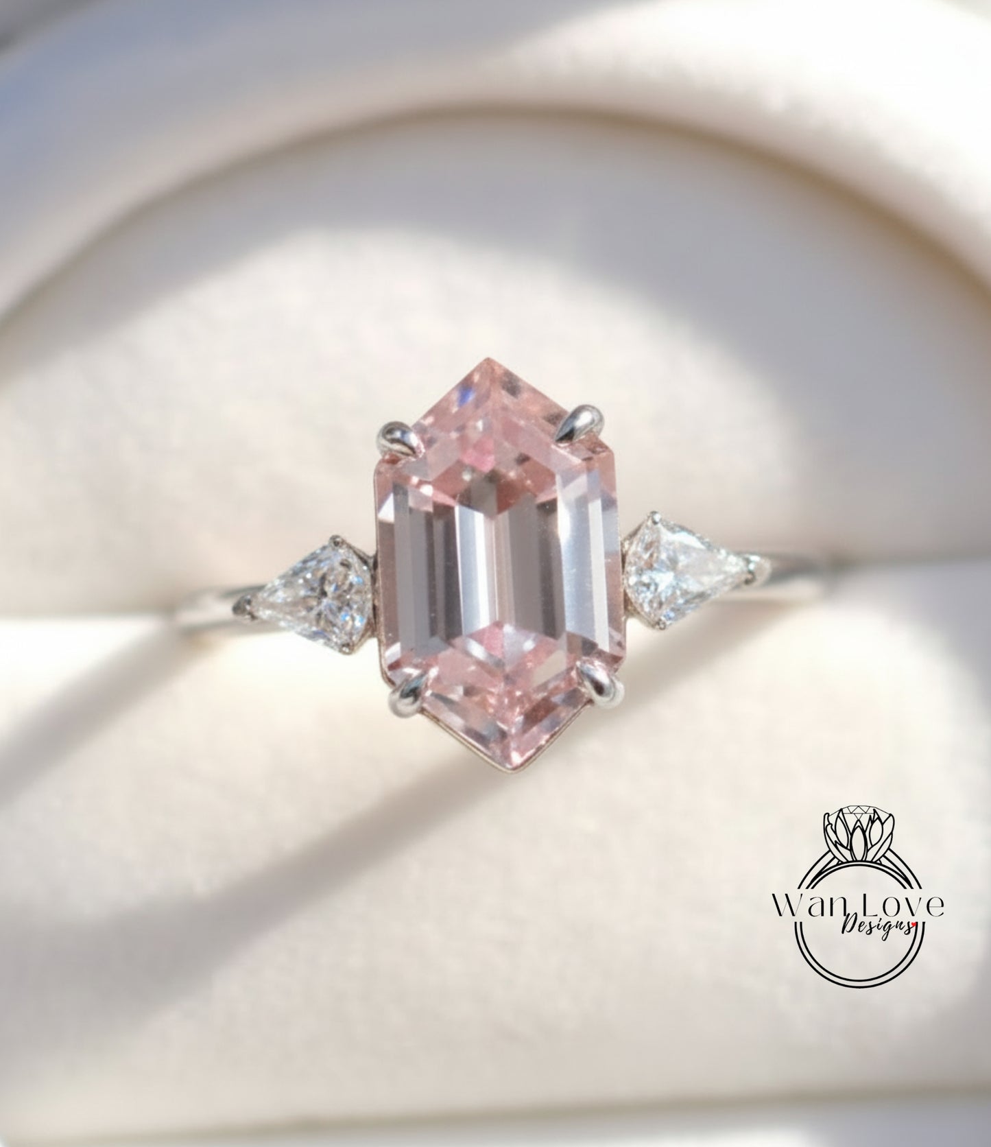 A close-up image of a diamond engagement ring with a large, pink gemstone set in a silver band.