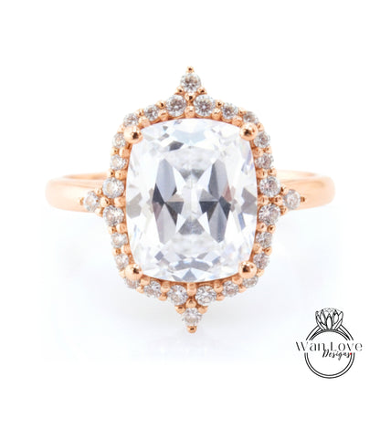 A large, clear gemstone ring with a halo of smaller diamonds around the center stone.
