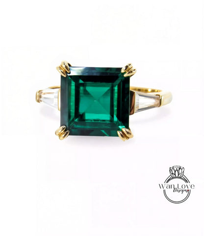 A gold ring with a large, square green gemstone set in the center.