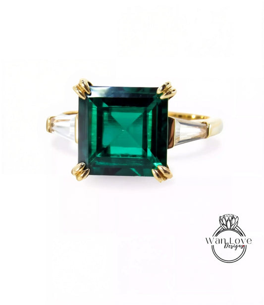A gold ring with a large, square green gemstone set in the center.