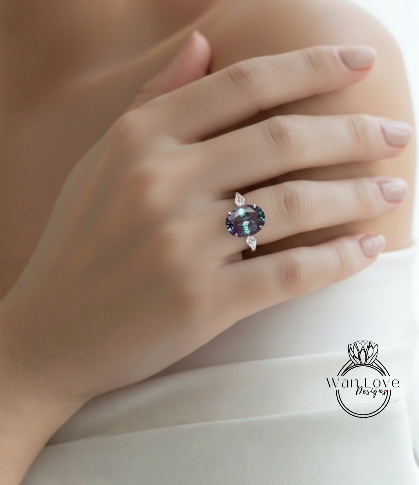 A close-up of a person's hand wearing a ring with a large, dark blue gemstone.