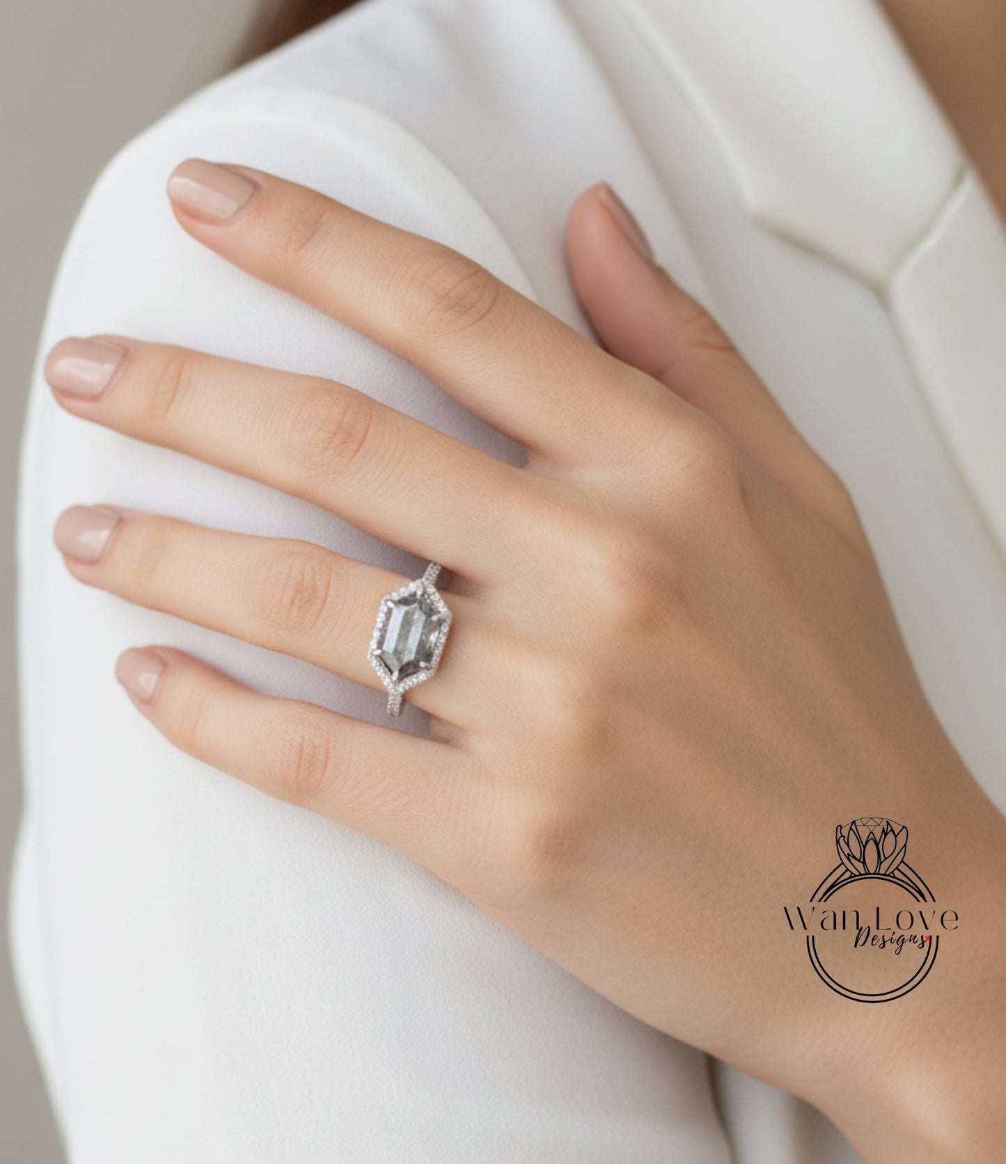 A close-up of a person's hand wearing a large diamond engagement ring.