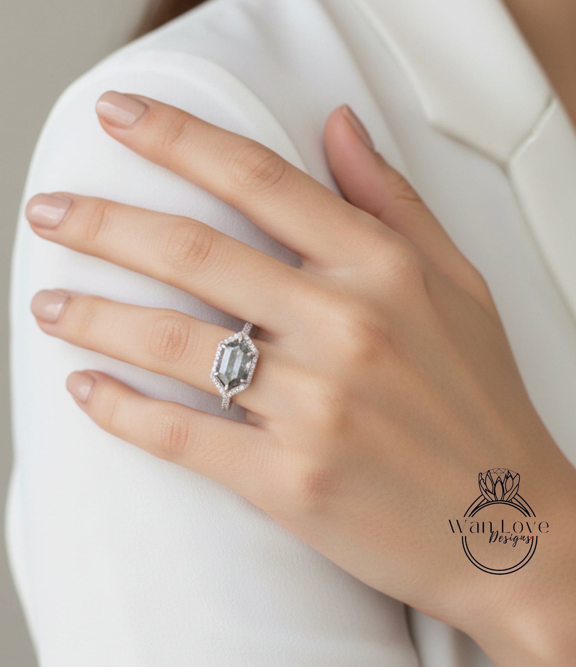 A close-up of a person's hand wearing a large diamond engagement ring.