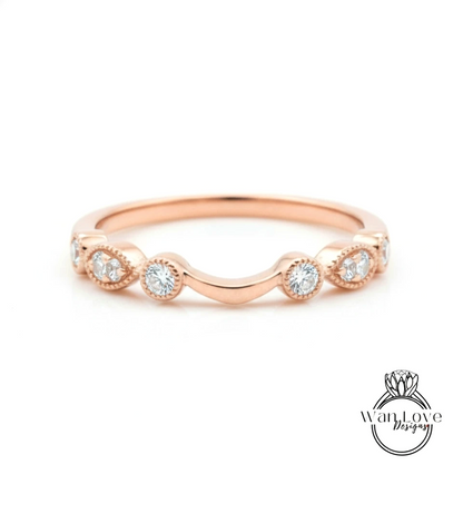 A rose gold ring with a curved band and a row of small diamonds set in the center.