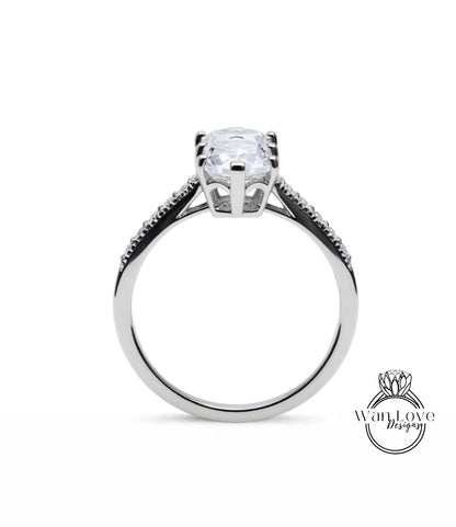 A silver engagement ring with a large, clear gemstone set in the center.