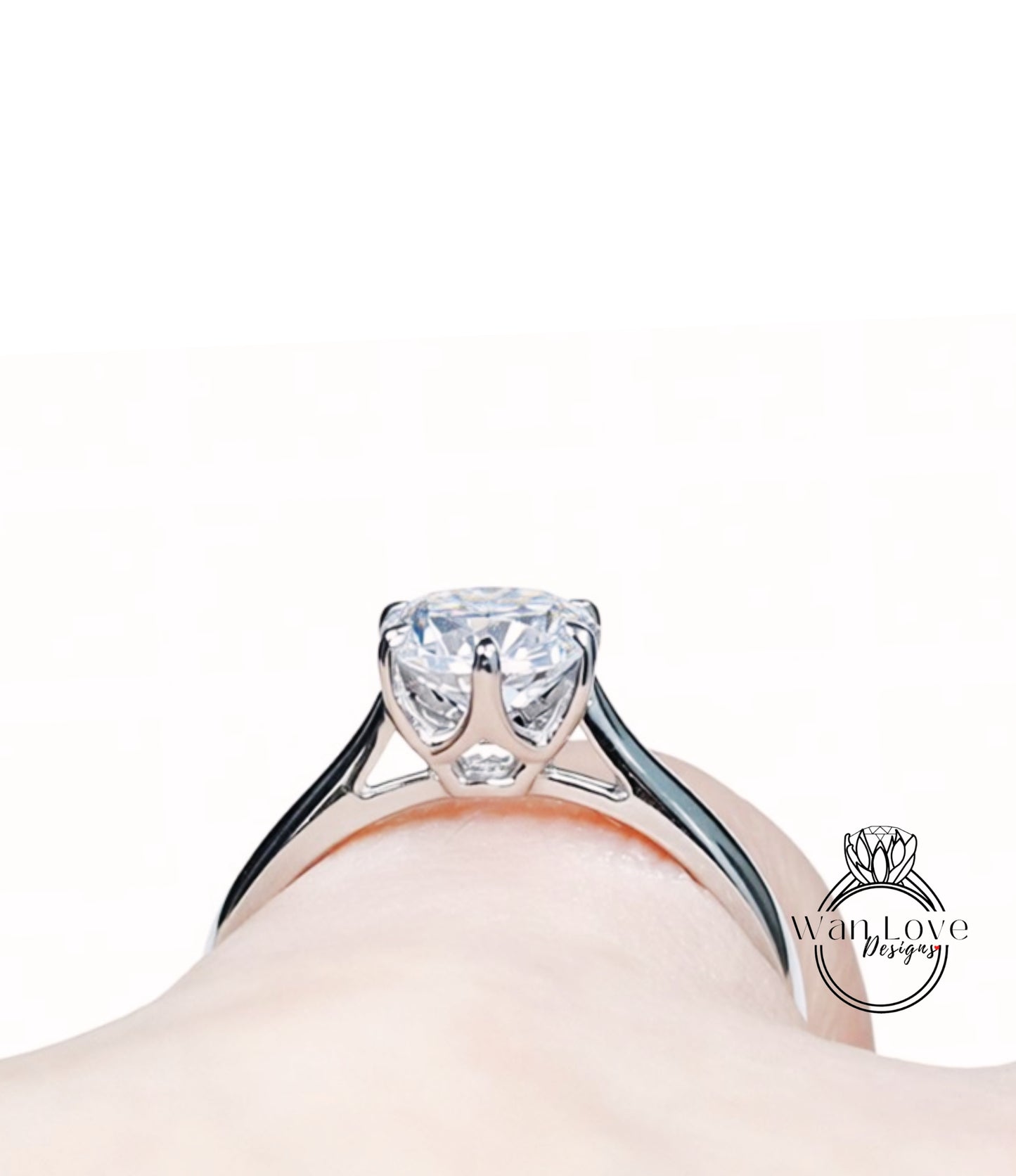 A close-up view of a diamond engagement ring on a person's hand, showcasing the intricate design and sparkling gemstone.