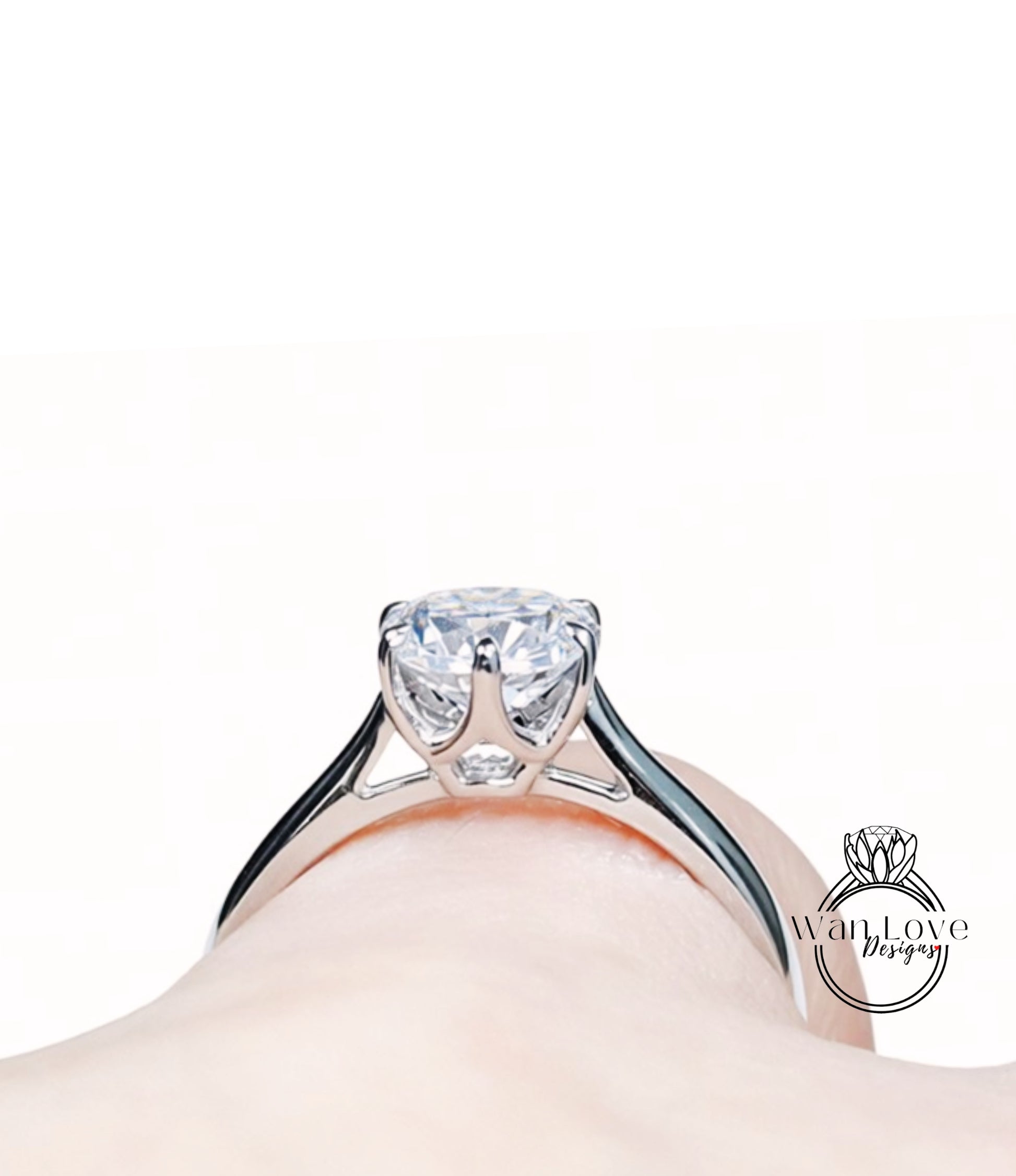 A close-up view of a diamond engagement ring on a person's hand, showcasing the intricate design and sparkling gemstone.