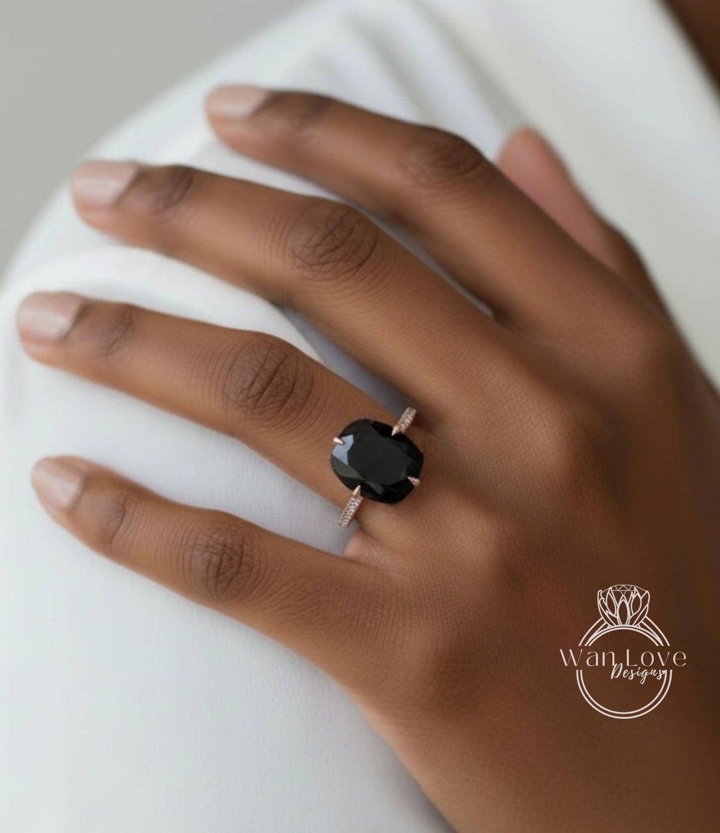 A close-up of a hand wearing a large black diamond ring.
