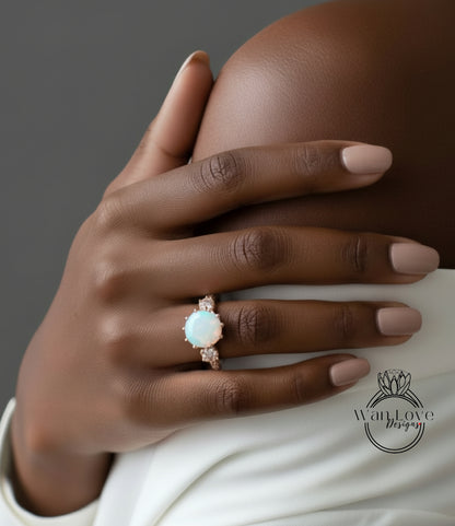 A close-up of a hand wearing a ring with a large opal stone.