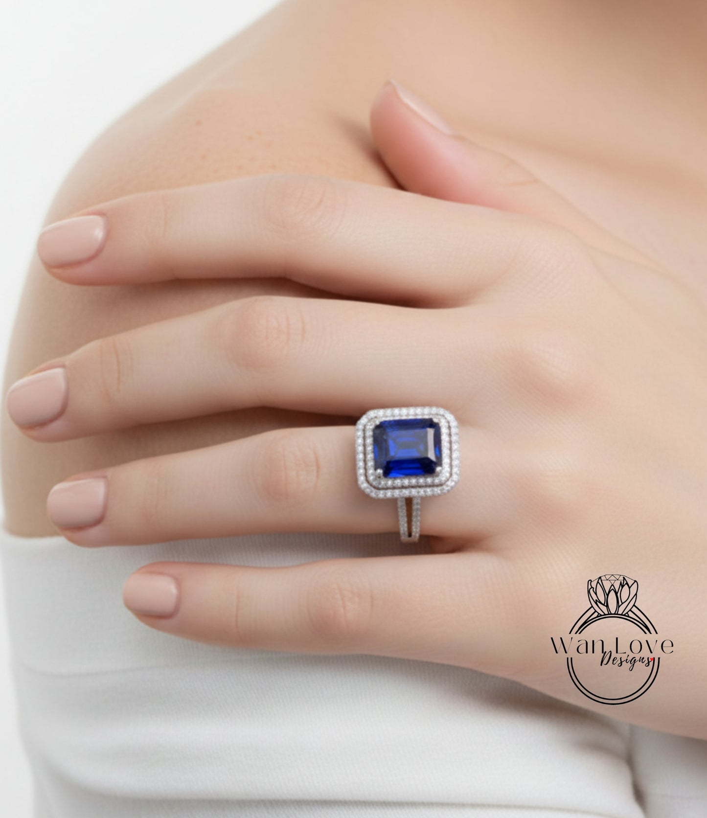 A close-up of a person's hand wearing a diamond ring with a large blue gemstone.