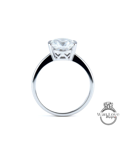 A silver engagement ring with a large, clear diamond set in the center of the band.