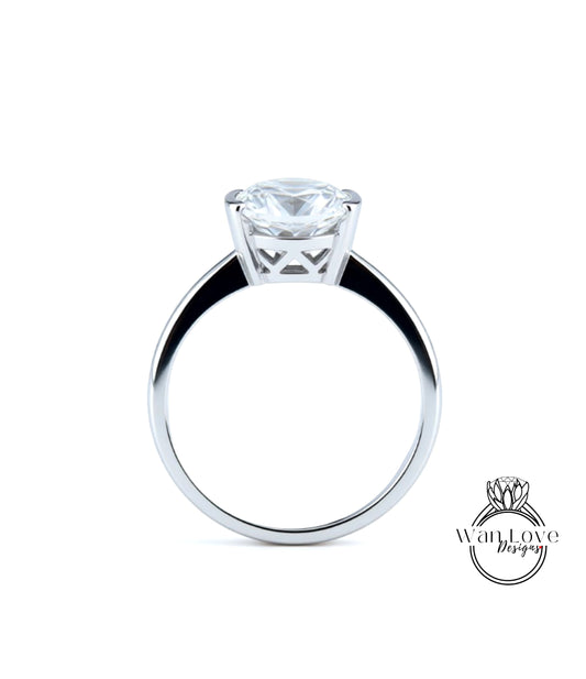 A silver engagement ring with a large, clear diamond set in the center of the band.