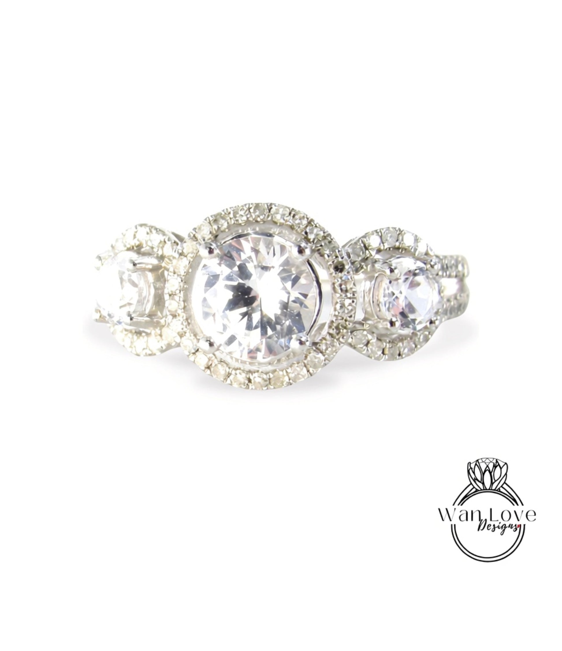 A close-up image of a diamond engagement ring with a large central diamond surrounded by smaller diamonds on the outer ring.