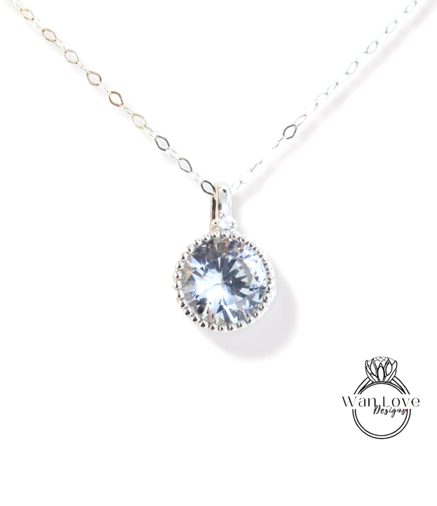 A silver necklace with a large, clear gemstone pendant.