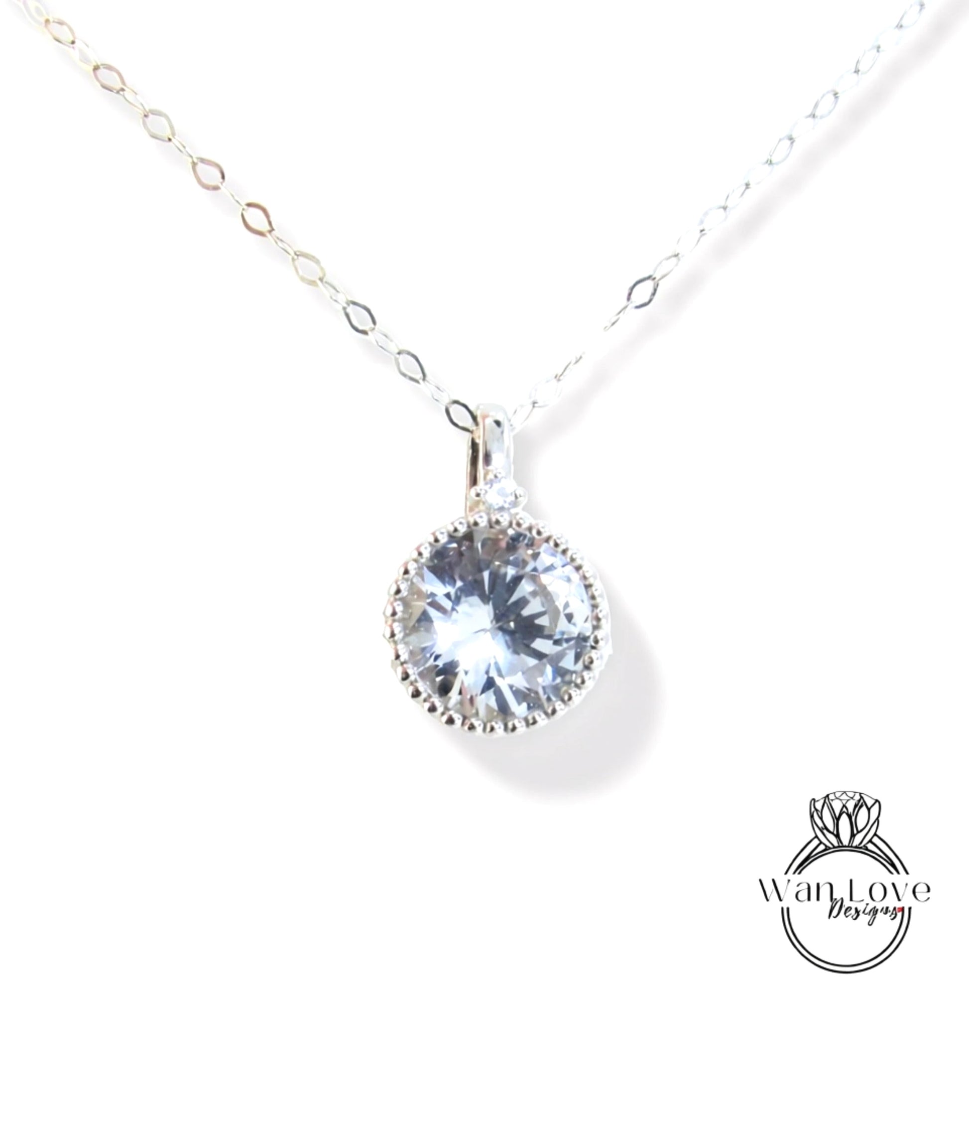 A silver necklace with a large, clear gemstone pendant.