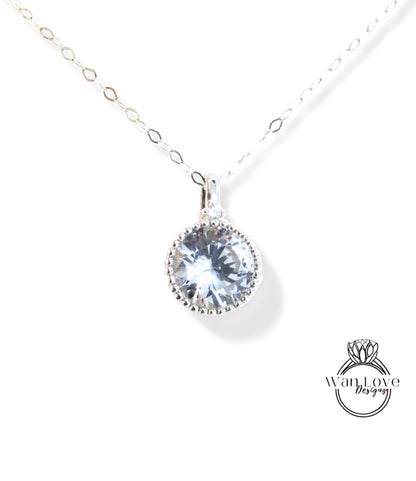 A silver necklace with a large, clear gemstone pendant.