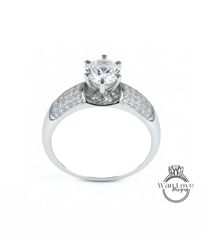 A silver ring with a large central diamond and smaller diamonds on either side.