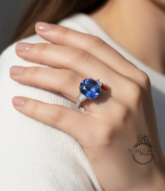 A close-up of a person's hand wearing a large blue gemstone ring.