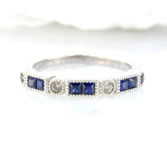 A silver ring adorned with blue and white gemstones, including diamonds and sapphires, set in a decorative pattern.