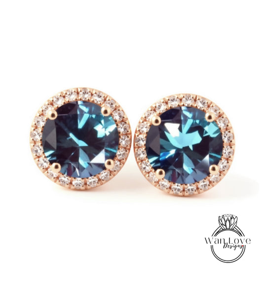 A pair of elegant earrings with blue gemstones set in a gold-toned halo, showcasing the intricate design and craftsmanship.