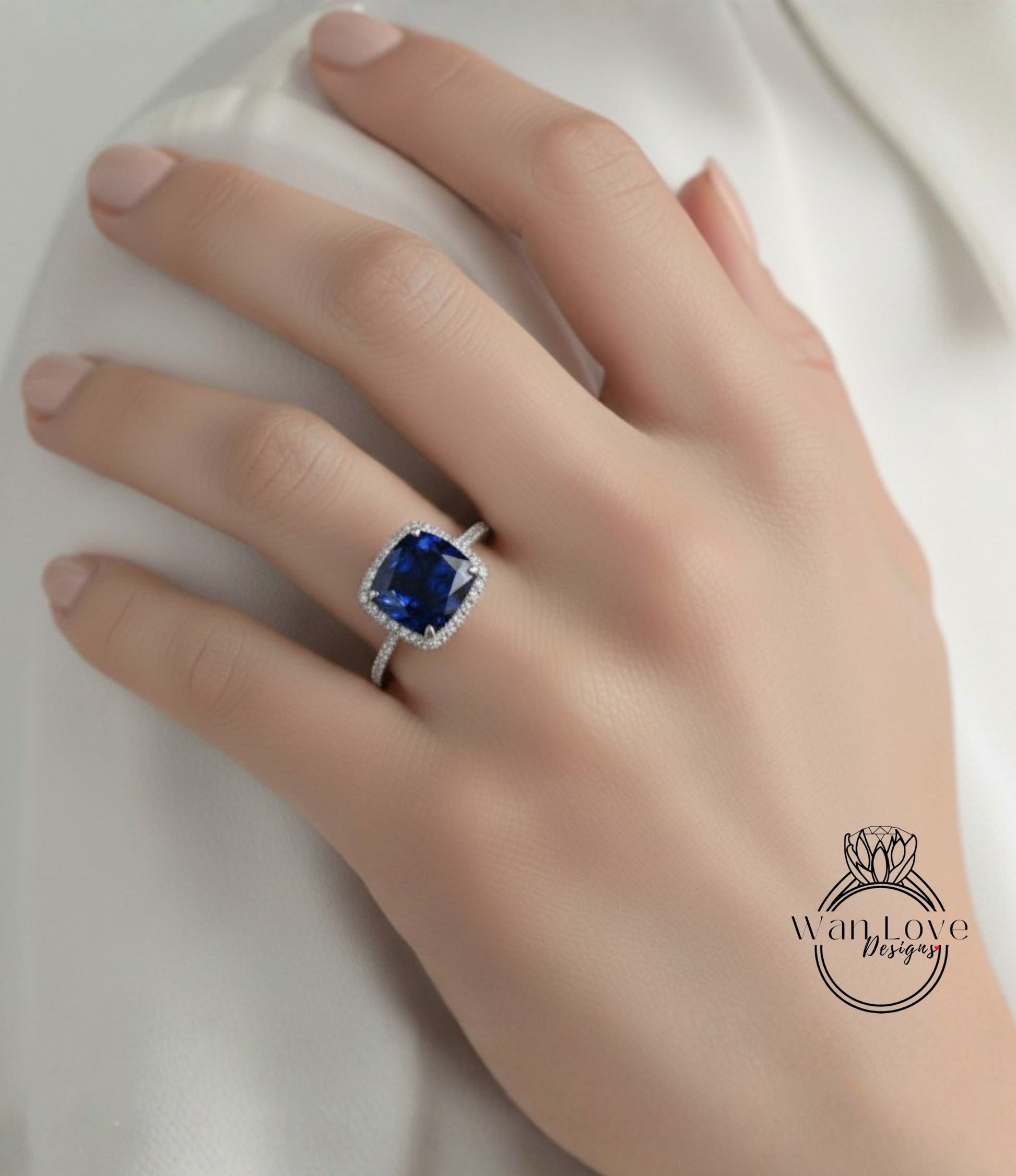 A close-up of a hand wearing a diamond ring with a large blue gemstone.