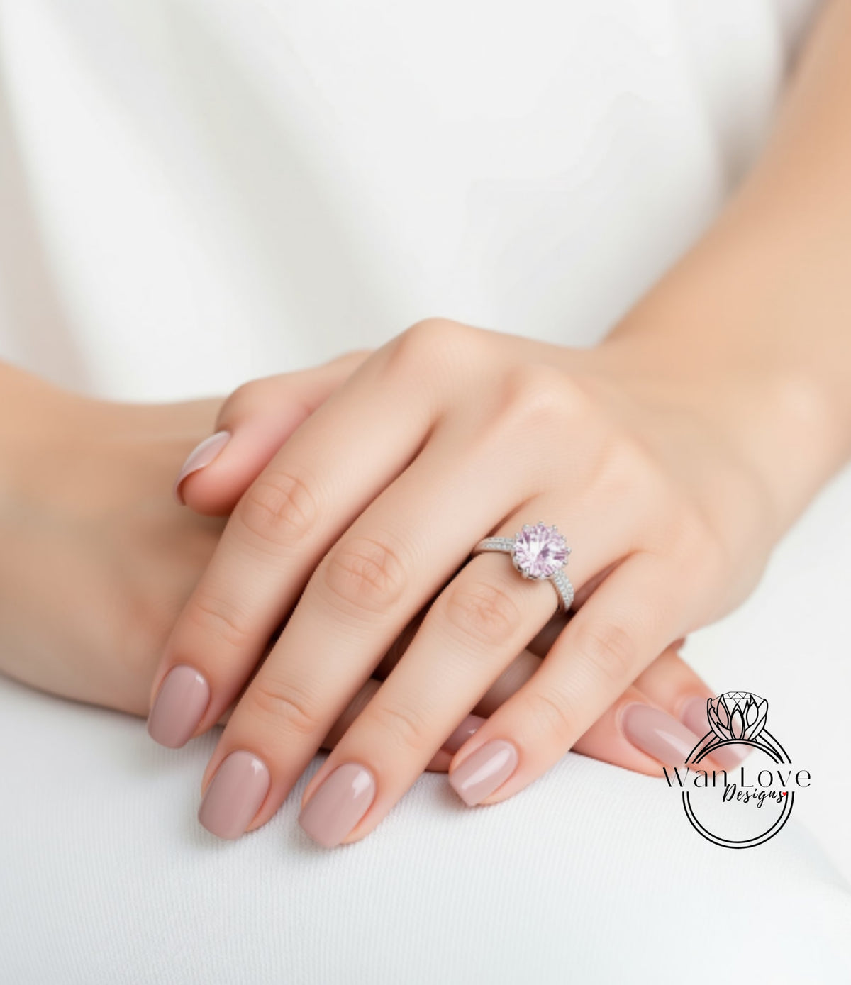 A close-up of a person's hand wearing a ring with a large pink gemstone.
