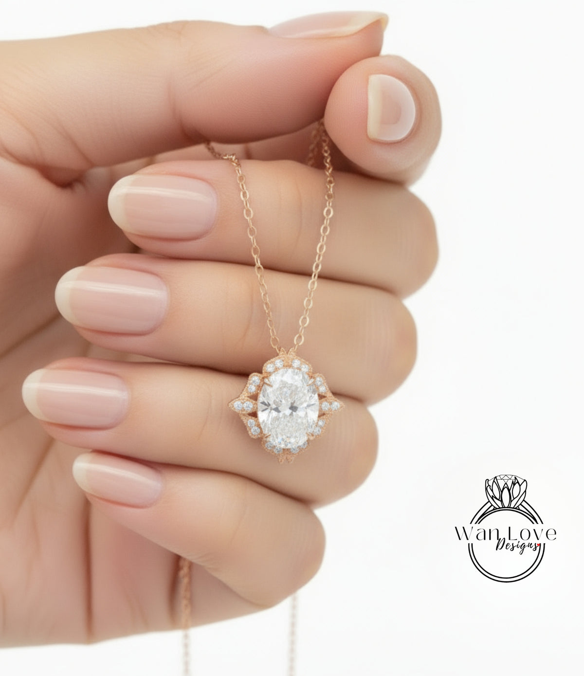 A hand holding a delicate gold necklace with a large oval-shaped diamond pendant.