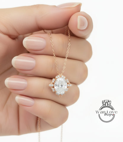 A hand holding a delicate gold necklace with a large oval-shaped diamond pendant.