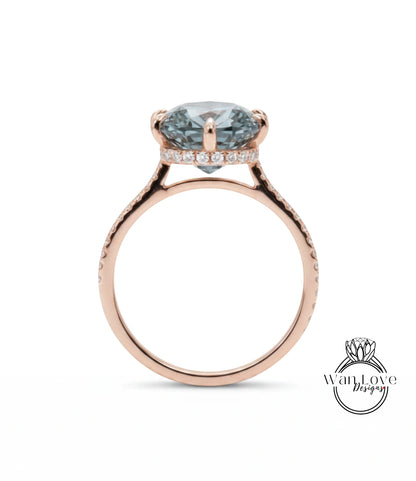 A rose gold engagement ring with a large blue gemstone set in the center, surrounded by smaller diamonds.