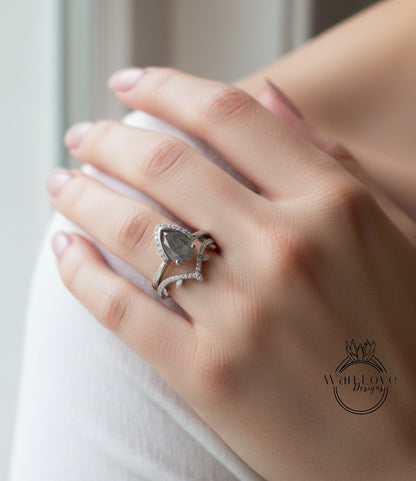 A close-up of a person's hand wearing a ring with a large diamond and a smaller diamond on the band.