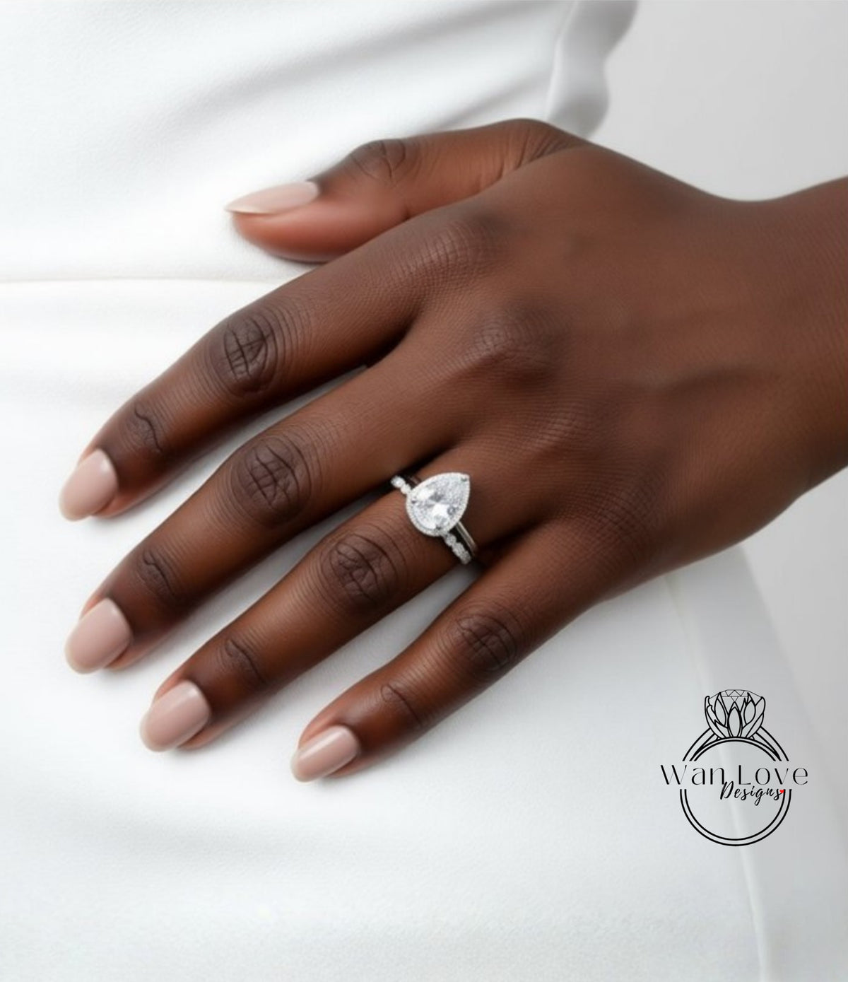A close-up of a hand wearing a diamond engagement ring.