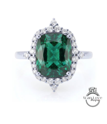 A large, oval-shaped green gemstone set in a silver ring with a halo of smaller diamonds around it.