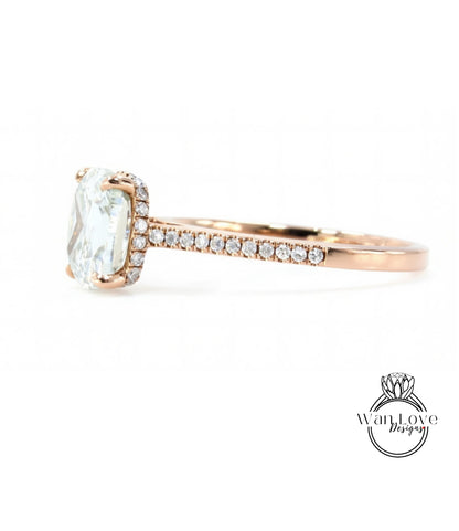 A close-up view of a diamond engagement ring with a large central diamond and a halo of smaller diamonds around it, set in a rose gold band.