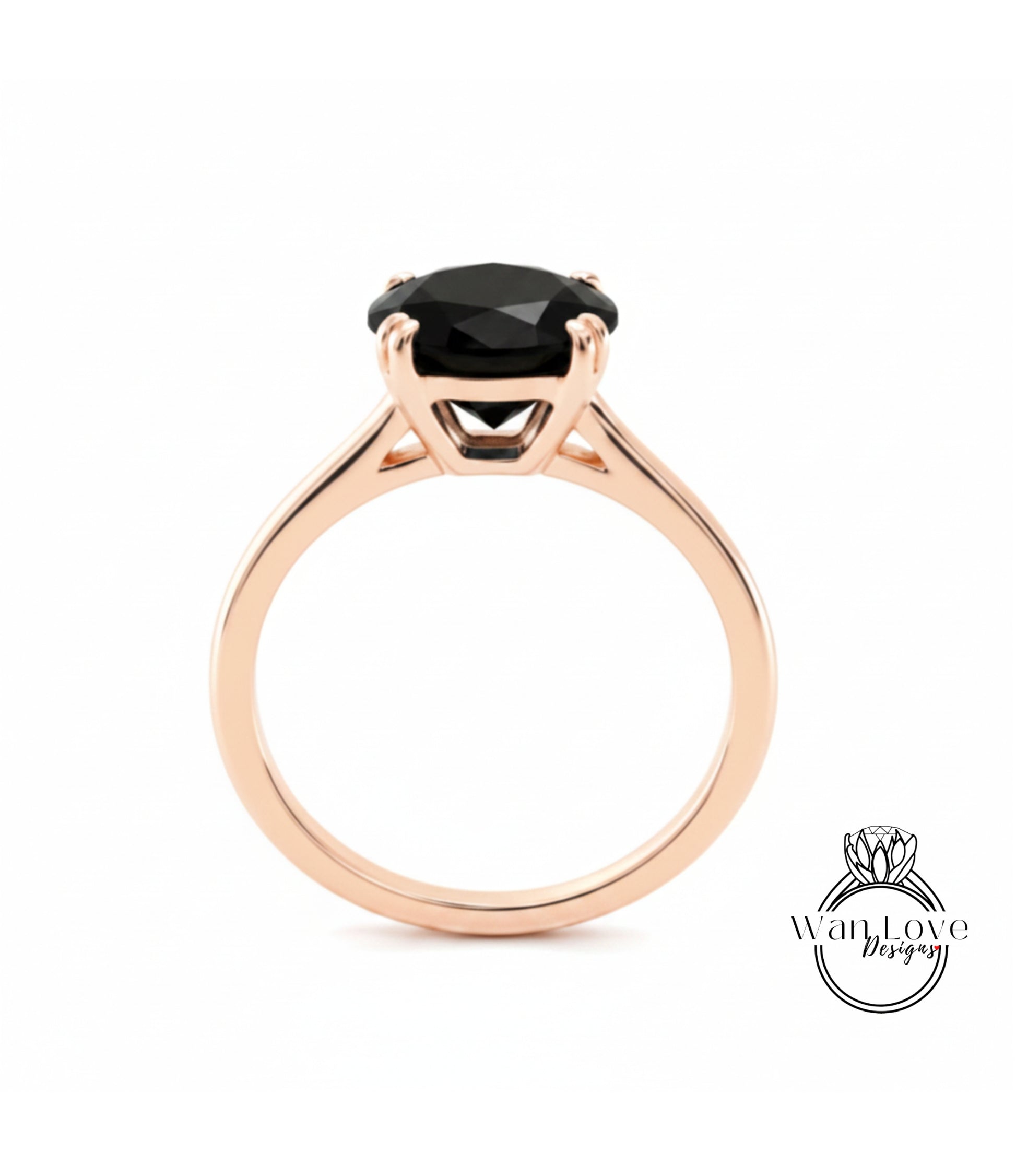 A rose gold engagement ring with a large black gemstone set in the center.