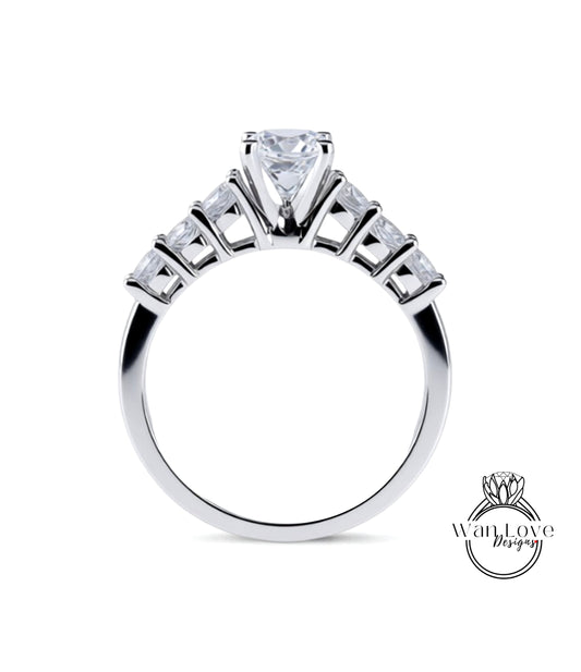 A close-up view of a silver engagement ring with a large central diamond surrounded by smaller diamonds arranged in a fan-like design on the band.